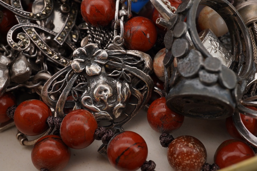 A mixed group of silver jewellery, including two charm bracelets, an Art Nouveau-style pendant; a pocket watch on chain; a pair of moonstone earrings; an onyx and marcasite pendant; a cross pendant; a carnelian pendant;